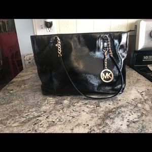 Michael Kors black tote bag with gold detail.